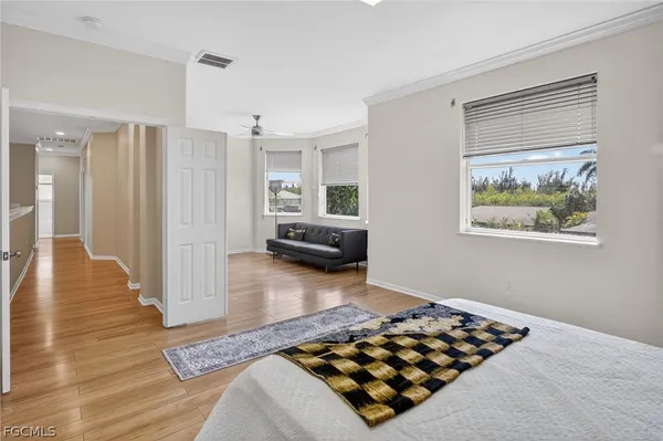 a bedroom with wooden floor and window