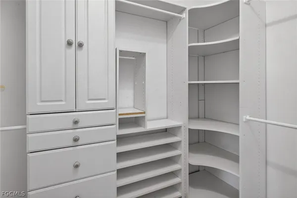 a view of walk in closet with empty racks