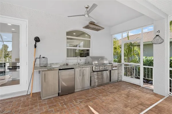 a kitchen with stainless steel appliances granite countertop a stove a sink dishwasher a refrigerator and a dining table with wooden floor