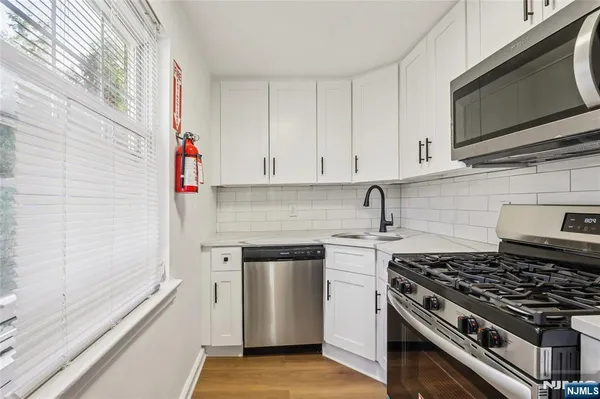 a kitchen with stainless steel appliances granite countertop a sink and a stove