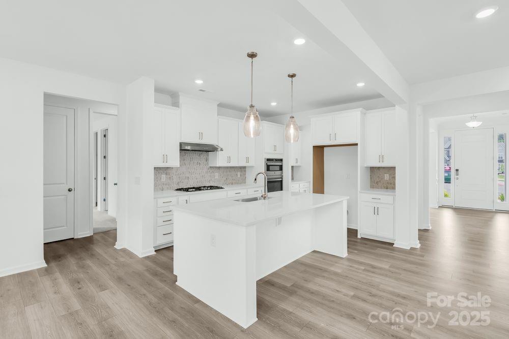 173 Glenn Drive Mooresville, NC 28115 - Photo 3 of 35 a large white kitchen with lots of counter space wooden floor and appliances