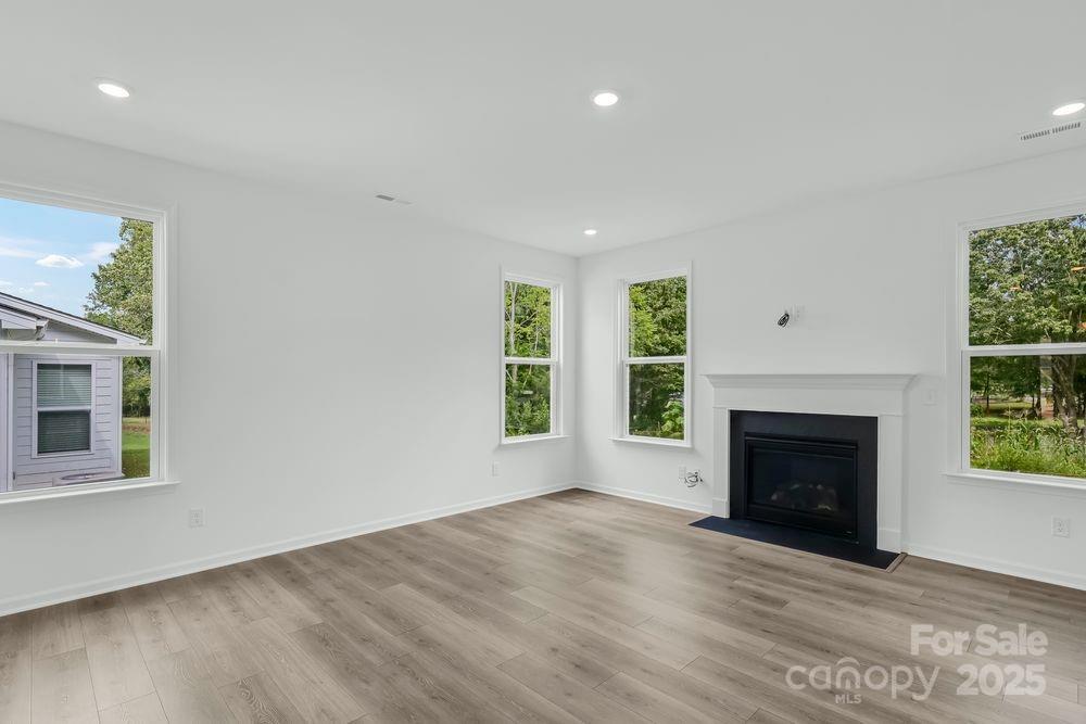 173 Glenn Drive Mooresville, NC 28115 - Photo 9 of 35 an empty room with windows and fireplace
