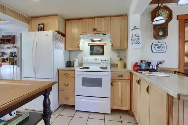 a kitchen with a refrigerator and a stove top oven
