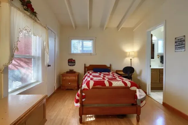 a bedroom with a bed and wooden floor