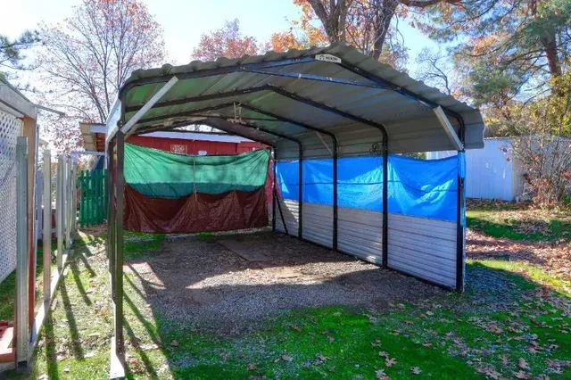 a view of a backyard with table and chairs and a large tree
