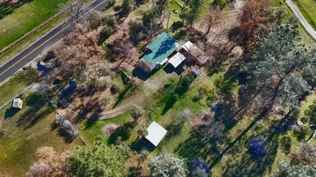 an aerial view of a house with a yard and lake view