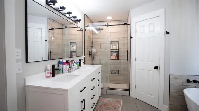 a bathroom with a double vanity sink mirror and shower