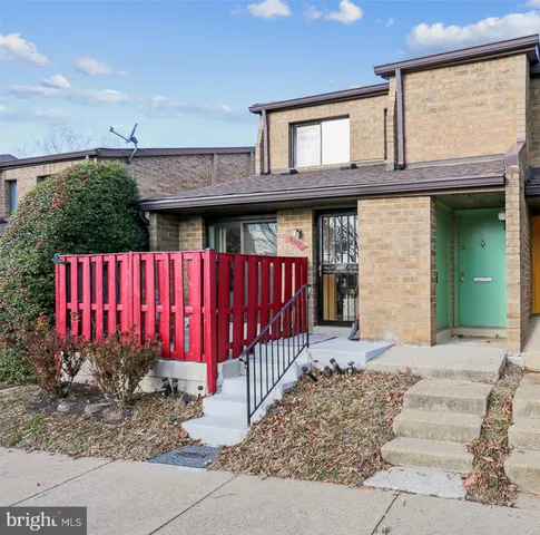a view of a house with a balcony and wooden fence