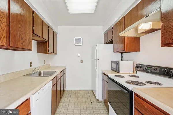 a kitchen with a sink stove top oven and cabinets