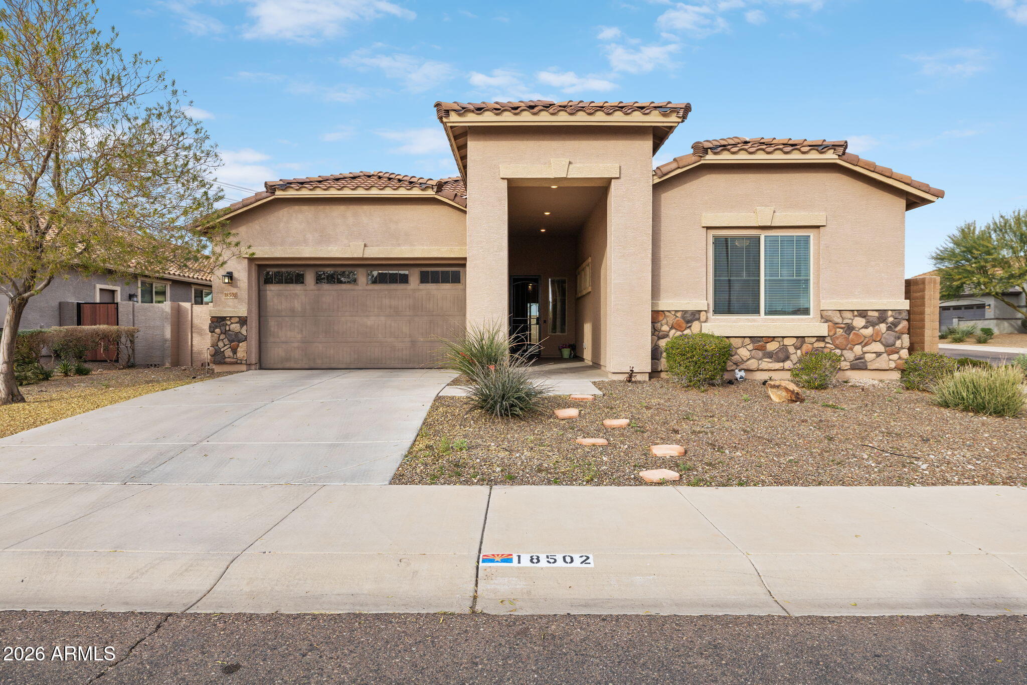 a front view of a house with garage and glass door