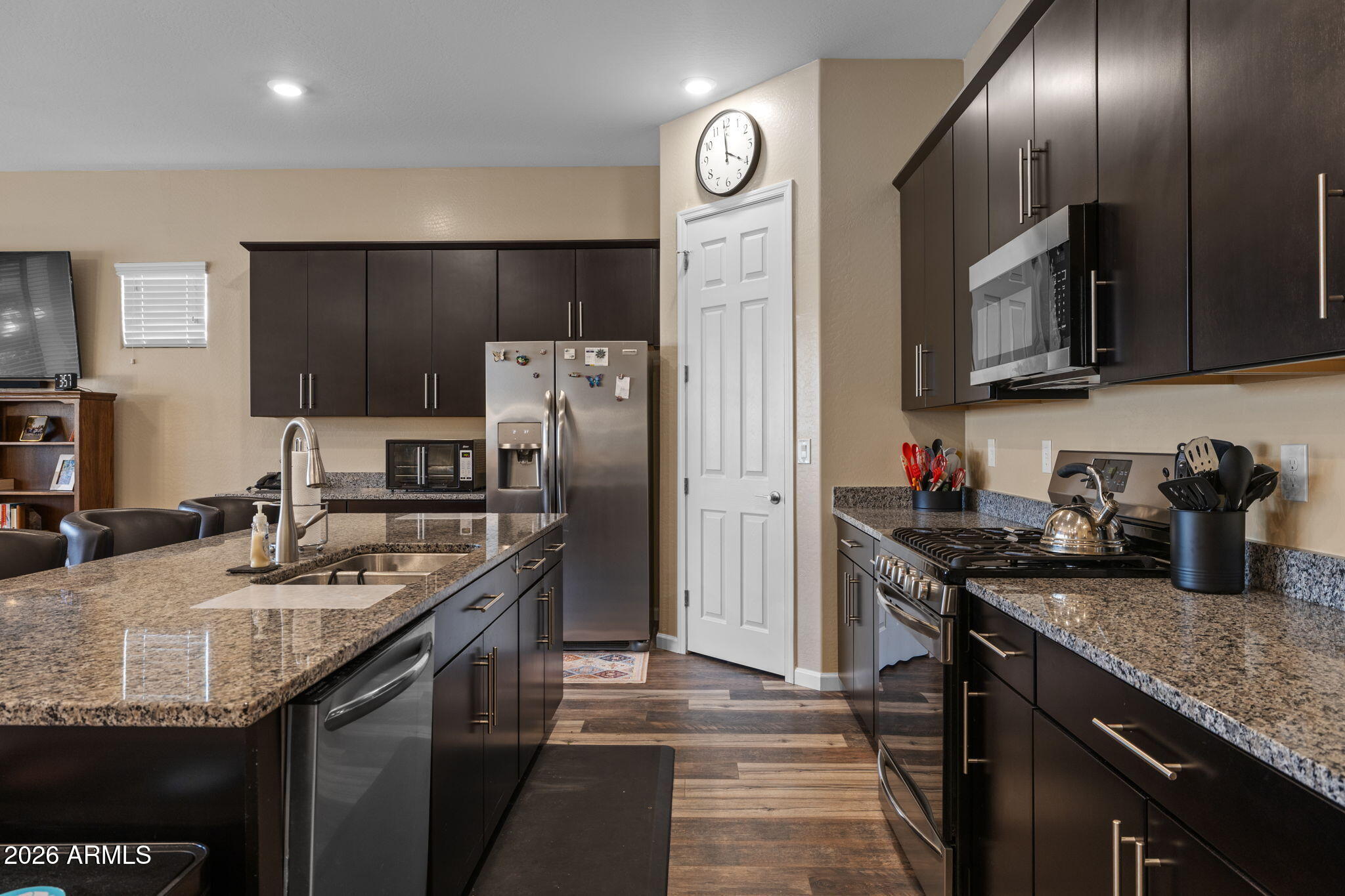 18502 West Desert Trumpet Road Goodyear, AZ 85338 - Photo 10 of 41 a kitchen with granite countertop kitchen island stainless steel appliances a sink stove refrigerator and a counter top space