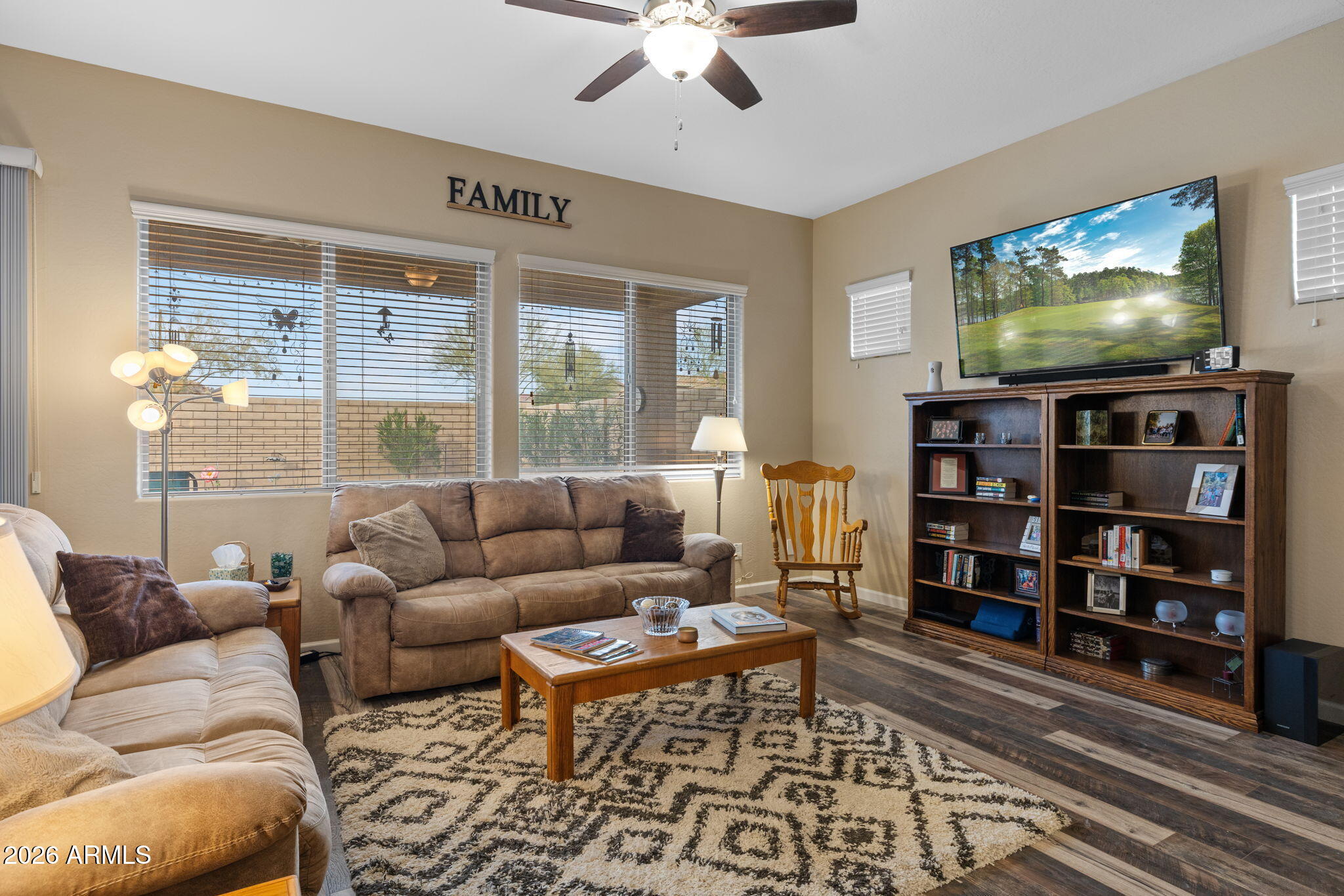18502 West Desert Trumpet Road Goodyear, AZ 85338 - Photo 12 of 41 a living room with furniture a flat screen tv and a floor to ceiling window