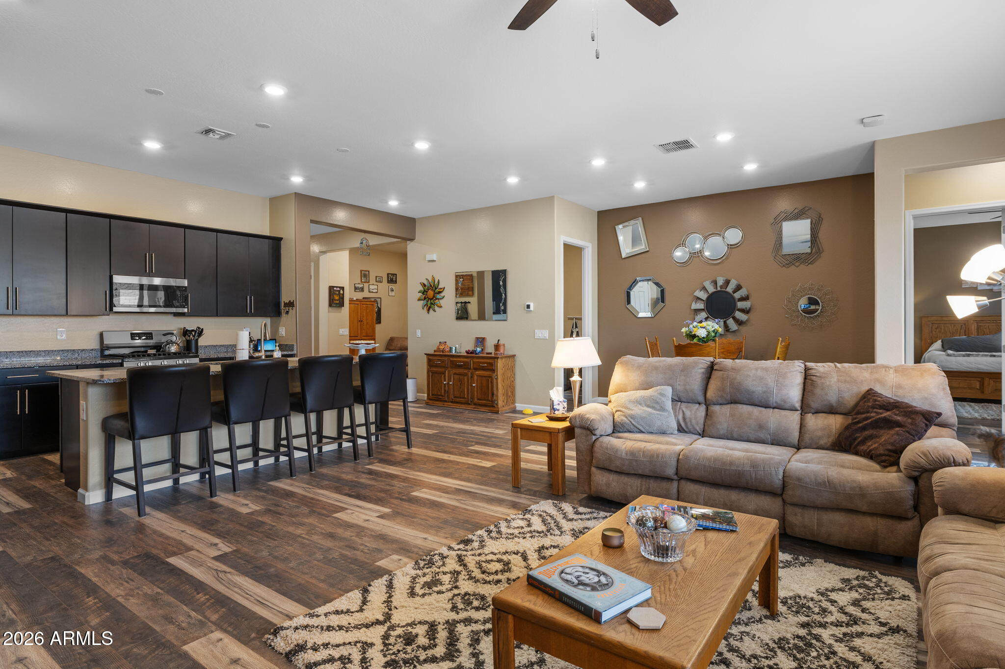 18502 West Desert Trumpet Road Goodyear, AZ 85338 - Photo 14 of 41 a living room kitchen with a dining table wooden floor and a kitchen view