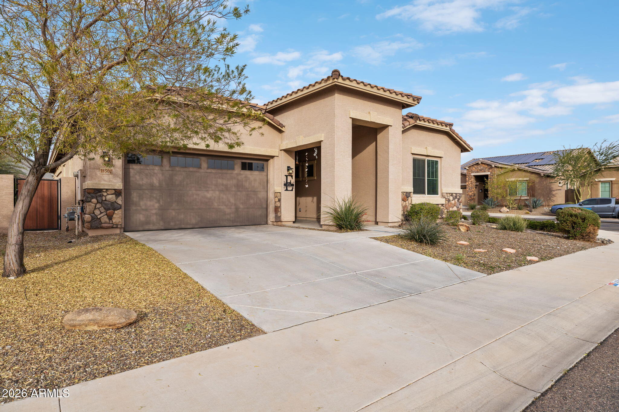 18502 West Desert Trumpet Road Goodyear, AZ 85338 - Photo 2 of 41 a front view of a house with a yard and garage