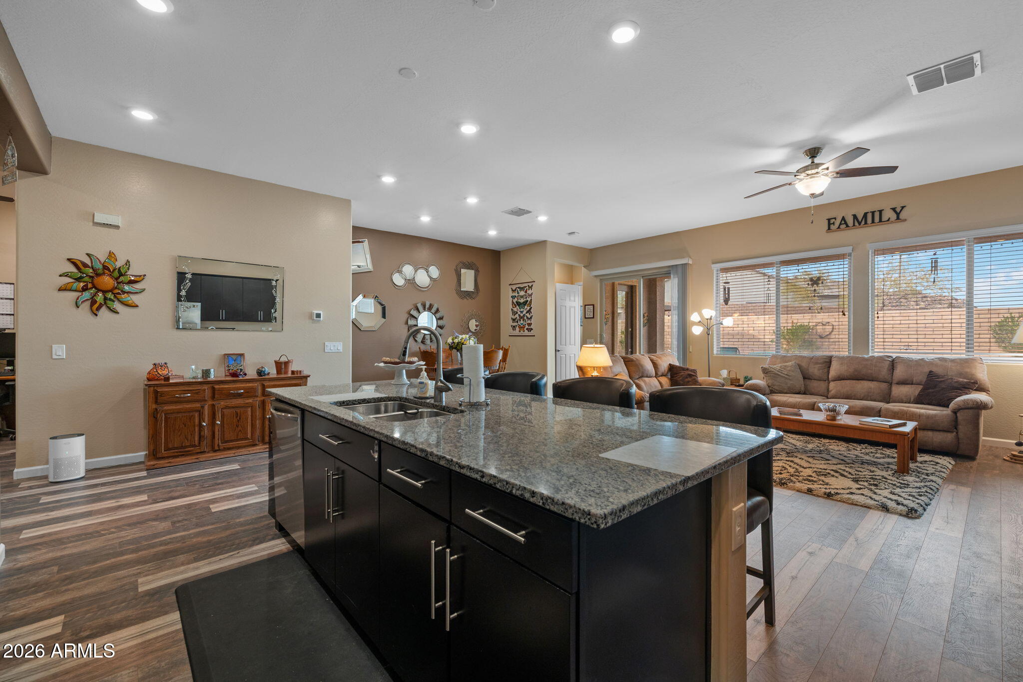 18502 West Desert Trumpet Road Goodyear, AZ 85338 - Photo 7 of 41 a kitchen with granite countertop a sink counter top space and living room view