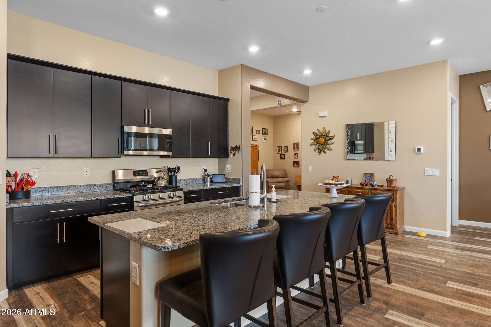 18502 West Desert Trumpet Road Goodyear, AZ 85338 - Photo 8 of 41 a kitchen with a stove a sink a microwave a dining table and chairs