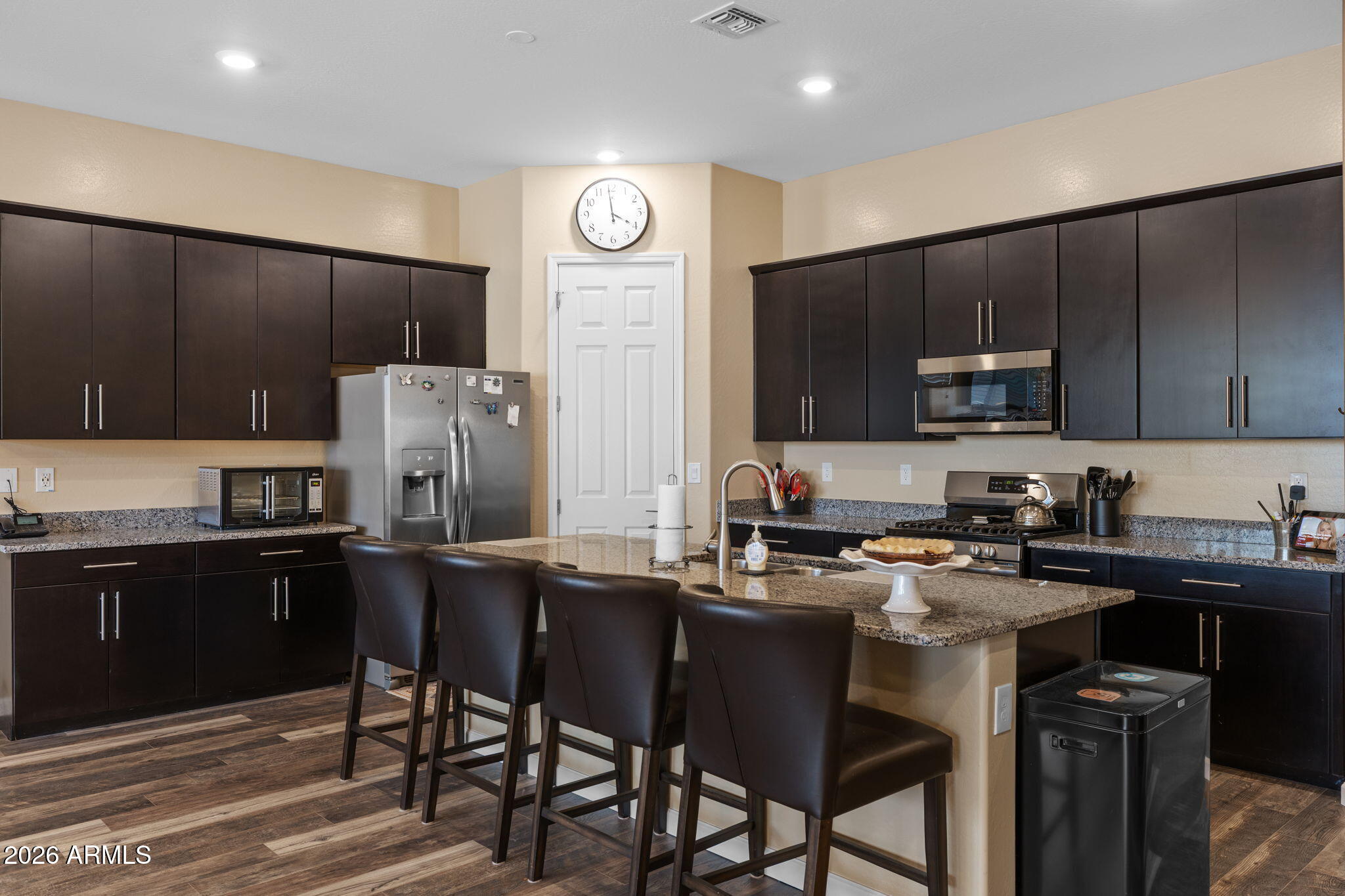 18502 West Desert Trumpet Road Goodyear, AZ 85338 - Photo 9 of 41 a kitchen with a sink a stove a refrigerator and chairs
