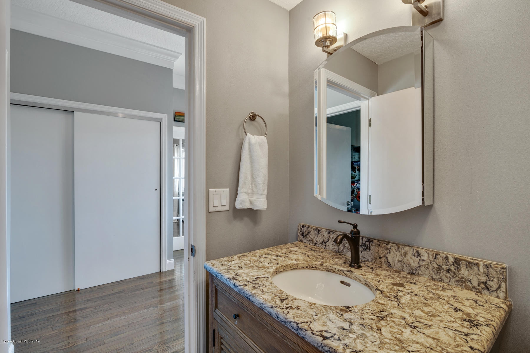 400 Richards Road Melbourne Beach, FL 32951 - Photo 39 of 59 a bathroom with a granite countertop sink and a mirror