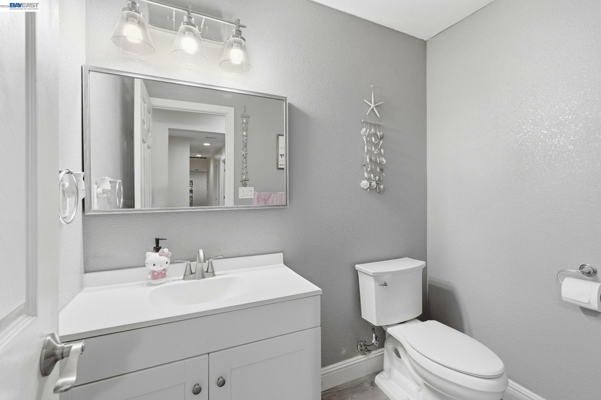 10378 South Priest Road French Camp, CA 95231 - Photo 33 of 44 a bathroom with a toilet a sink a mirror and vanity