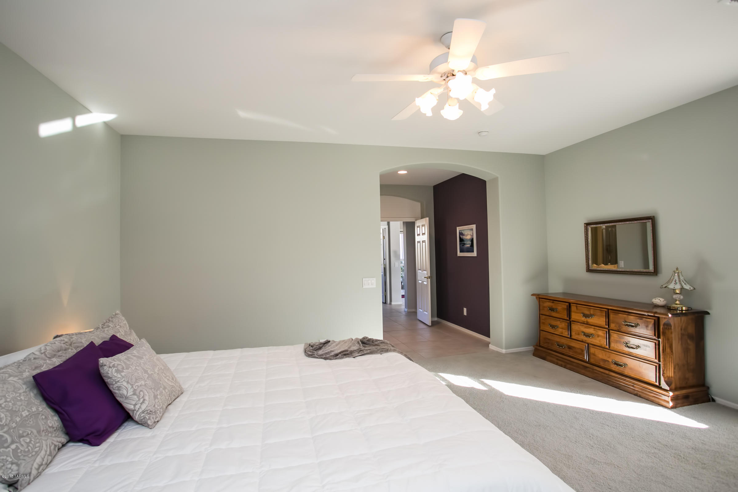 62419 East Northwood Road Tucson, AZ 85739 - Photo 20 of 30 a bedroom with a bed and a chandelier