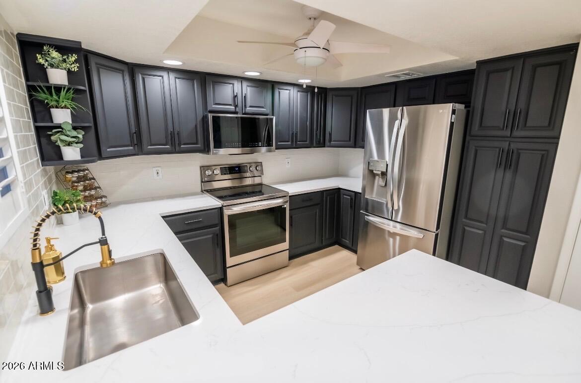 4303 East Cactus Road, Unit 128 Phoenix, AZ 85032 - Photo 17 of 39 a kitchen with stainless steel appliances granite countertop a refrigerator a stove top oven a sink dishwasher and wooden cabinets