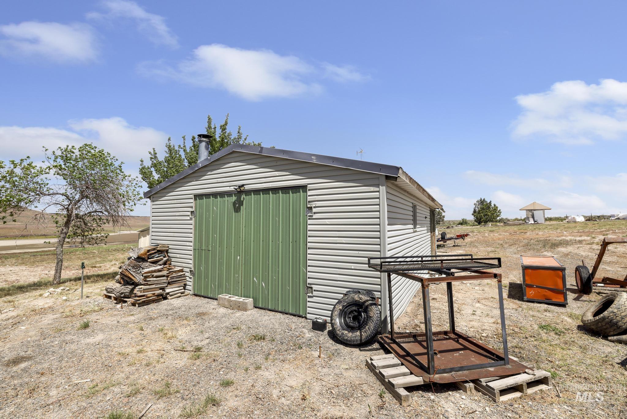 758 Cedar Crk Road Rogerson, ID 83302 - Photo 27 of 50 Utility shed with horizontal siding, a dark roof, a chimney, and a green double-door entry
