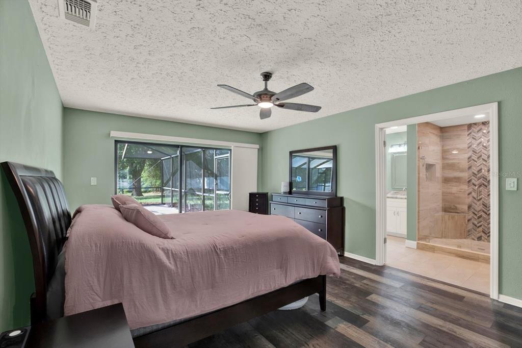 7487 River Country Drive Weeki Wachee, FL 34607 - Photo 25 of 53 a bedroom with a large bed and a chandelier