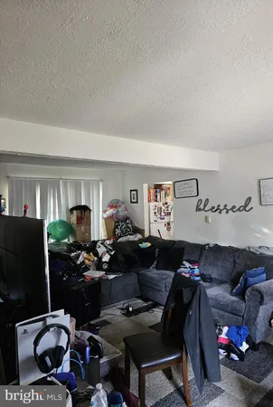 a living room with furniture a flat screen tv and a window