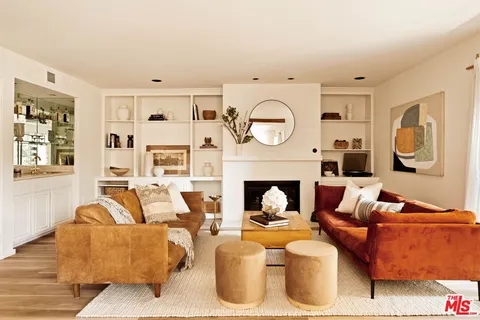 a living room with furniture a clock and a fireplace