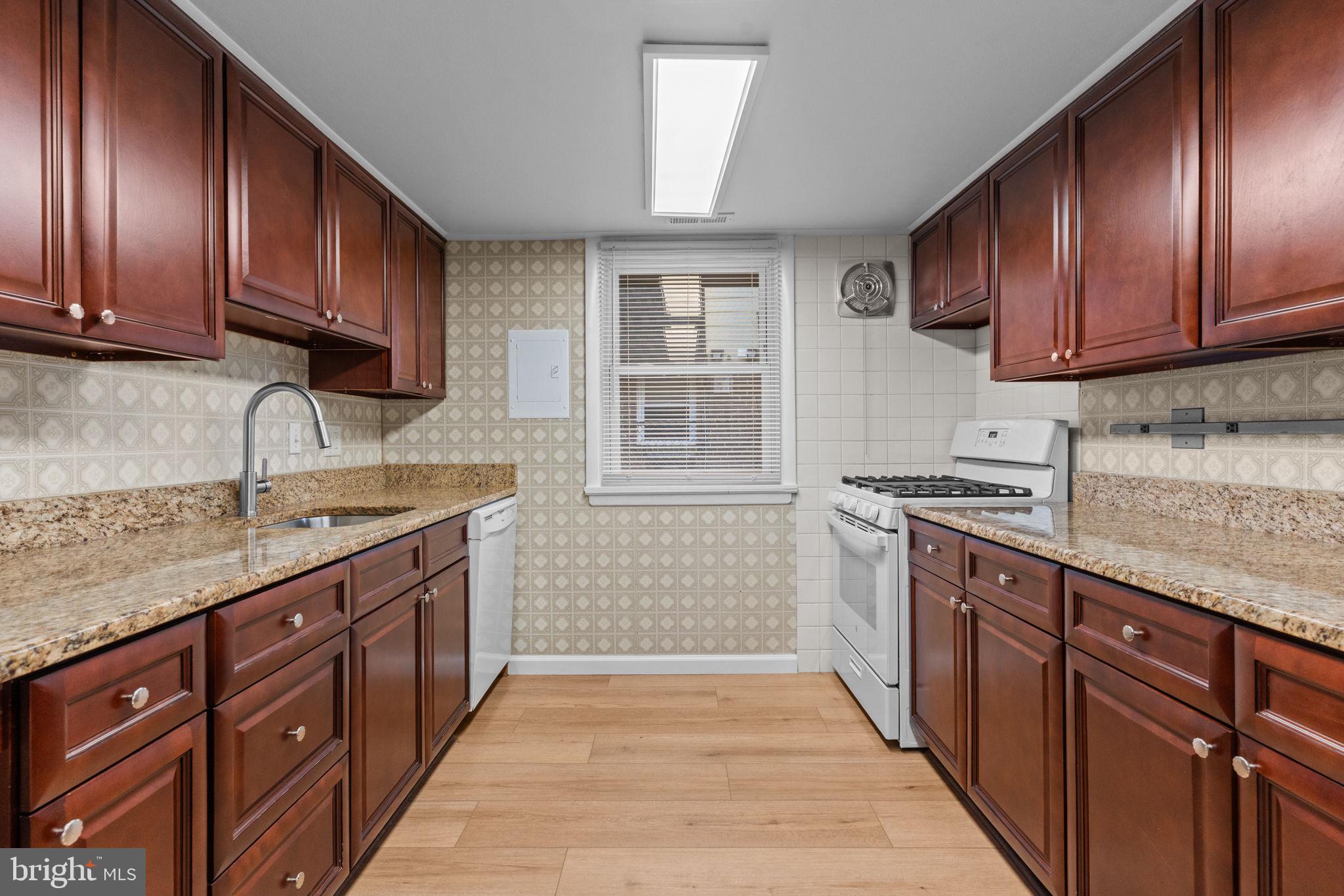 9823 Bonner Street Philadelphia, PA 19115 - Photo 8 of 29 a kitchen with stainless steel appliances granite countertop wooden cabinets a sink and dishwasher a stove top oven with wooden floor
