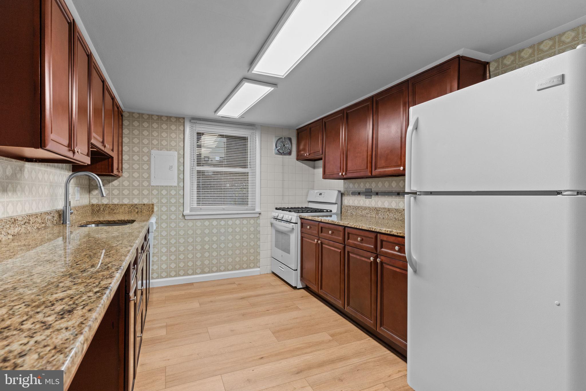 9823 Bonner Street Philadelphia, PA 19115 - Photo 9 of 29 a kitchen with stainless steel appliances granite countertop a refrigerator a sink dishwasher a stove with wooden cabinets and floor