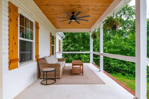 a view of a chairs and table in patio with a small yard