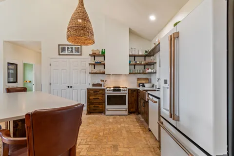 a kitchen with stainless steel appliances granite countertop a stove and a refrigerator