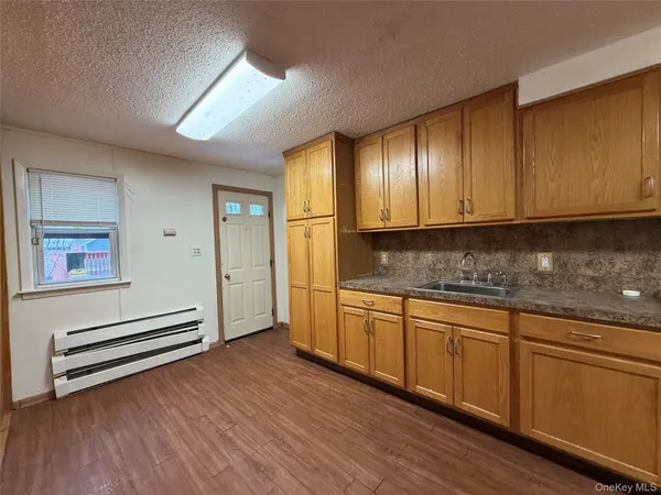 a kitchen with granite countertop wooden cabinets and white appliances
