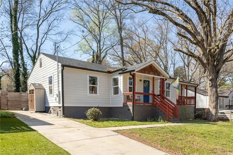 a front view of a house with yard and trees