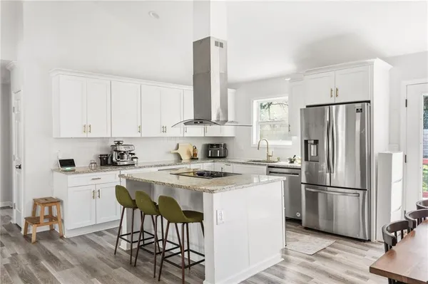 a kitchen with a stove a refrigerator and white cabinets