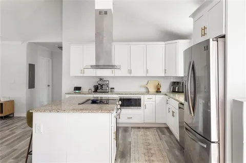 a kitchen with stainless steel appliances granite countertop a refrigerator sink and stove