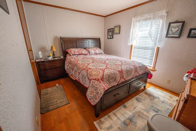 a kitchen with stainless steel appliances granite countertop a refrigerator a sink dishwasher a stove and a dining table with wooden floor