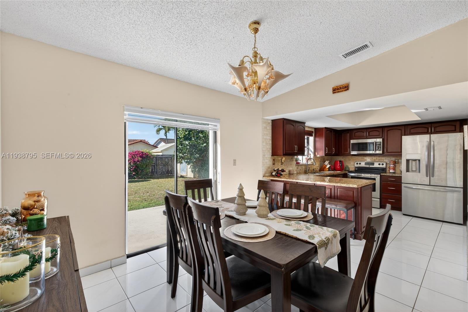 1136 Southwest 139th Place Miami, FL 33184 - Photo 21 of 42 a view of a dining room with furniture and a chandelier