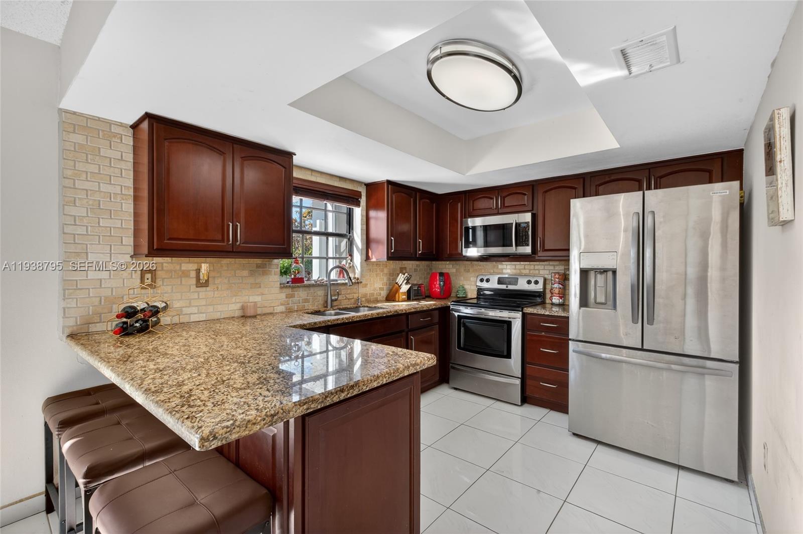 1136 Southwest 139th Place Miami, FL 33184 - Photo 22 of 42 a kitchen with granite countertop stainless steel appliances a stove refrigerator sink and cabinets