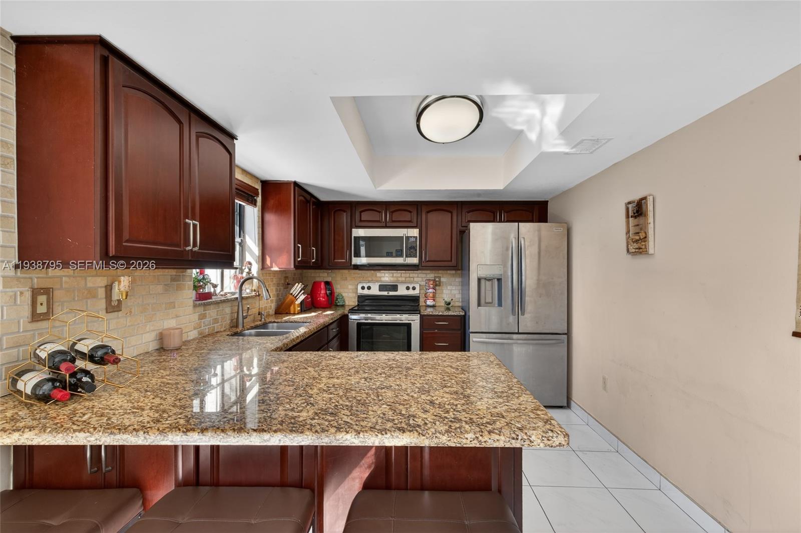 1136 Southwest 139th Place Miami, FL 33184 - Photo 23 of 42 a kitchen with stainless steel appliances granite countertop a sink stove and refrigerator