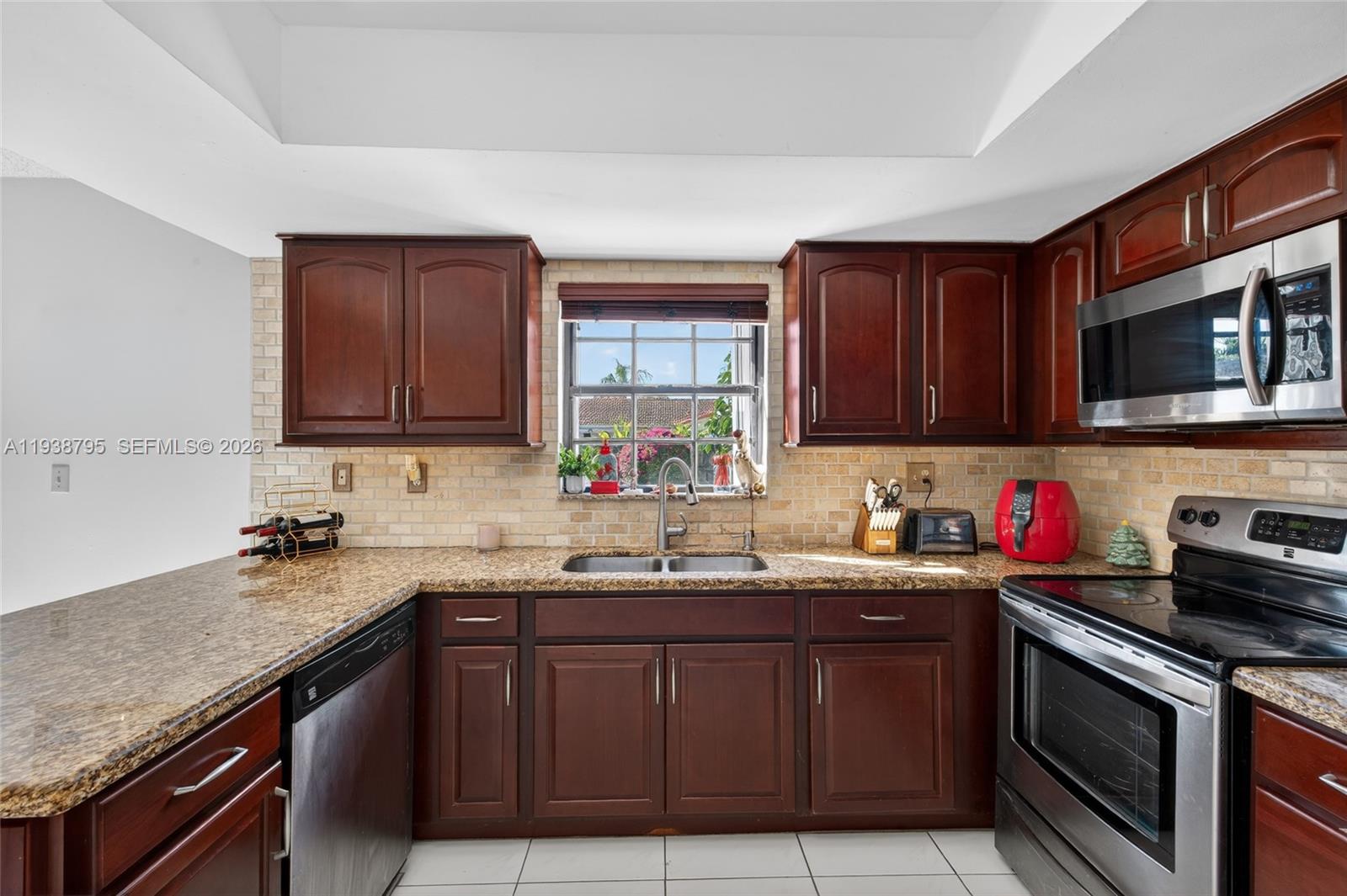 1136 Southwest 139th Place Miami, FL 33184 - Photo 24 of 42 a kitchen with stainless steel appliances granite countertop a sink stove and cabinets