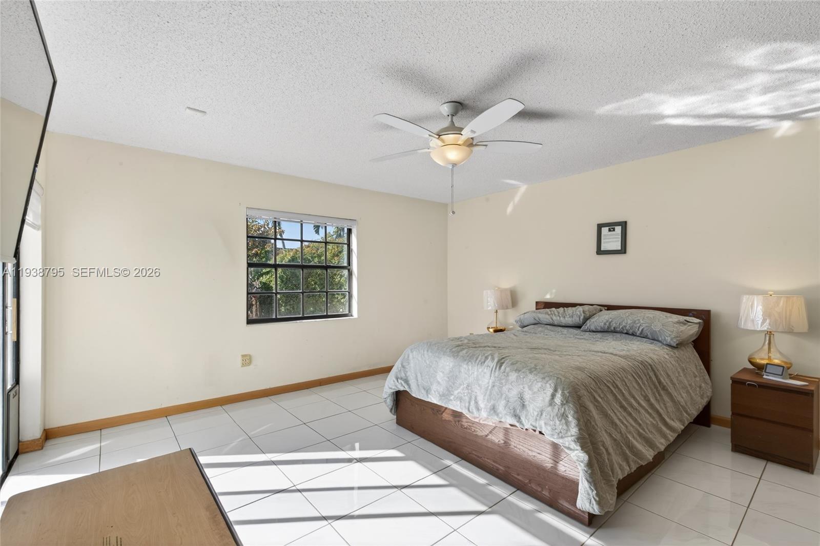 1136 Southwest 139th Place Miami, FL 33184 - Photo 27 of 42 a bedroom with a large bed and a ceiling fan