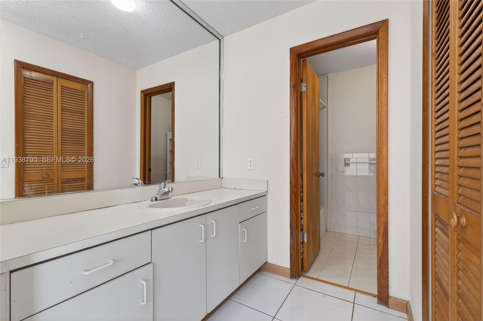 1136 Southwest 139th Place Miami, FL 33184 - Photo 30 of 42 a bathroom with a double vanity sink a mirror and a shower