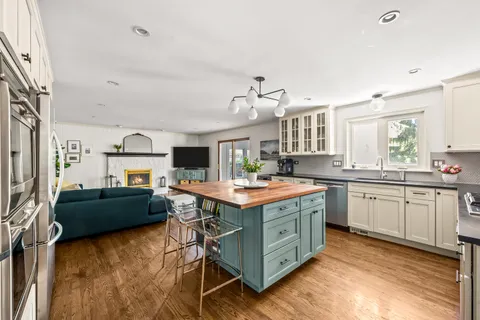 a kitchen that has a lot of cabinets in it and wooden floors