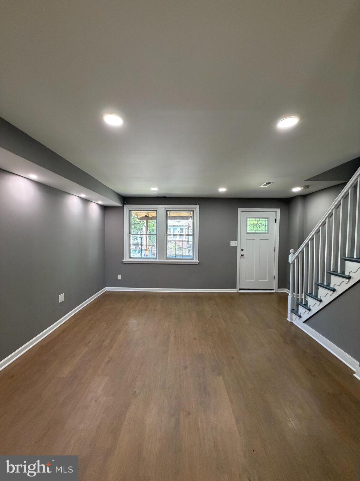 1353 Cambria Street Baltimore, MD 21225 - Photo 3 of 23 an empty room with wooden floor and windows