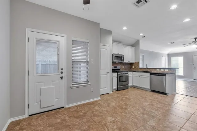 a kitchen with granite countertop a refrigerator and a stove top oven