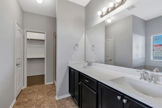 a spacious bathroom with a double vanity sink a vanity and a mirror