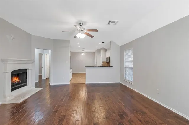 a view of empty room with wooden floor and fireplace
