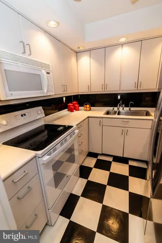 a kitchen with white cabinets and white appliances